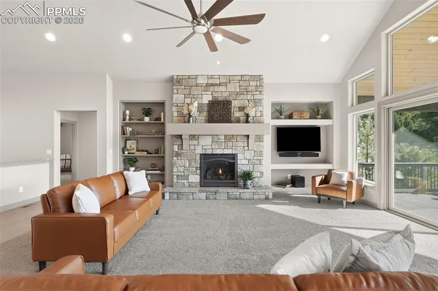 a living room with furniture a flat screen tv and a fireplace