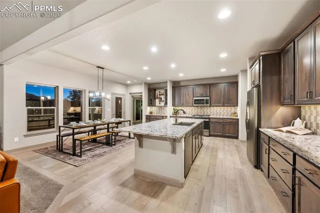 a kitchen with stainless steel appliances kitchen island granite countertop a large stove a sink a refrigerator and island