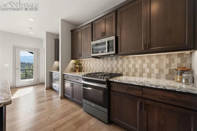 a kitchen with granite countertop cabinets stainless steel appliances and wooden floor