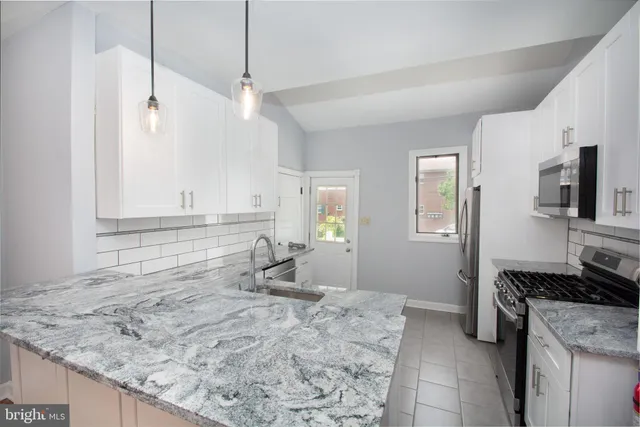 a kitchen with a stove a refrigerator and a sink