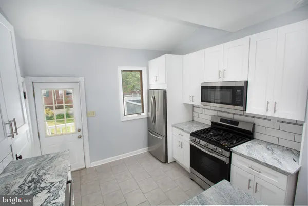 a kitchen with stainless steel appliances granite countertop a stove and a refrigerator