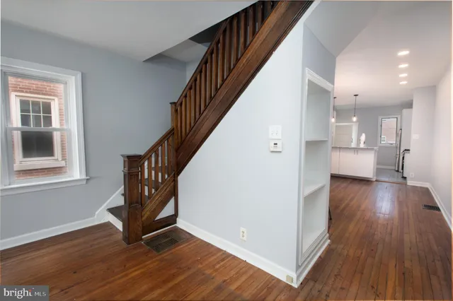a view of an entryway with wooden floor and staircase