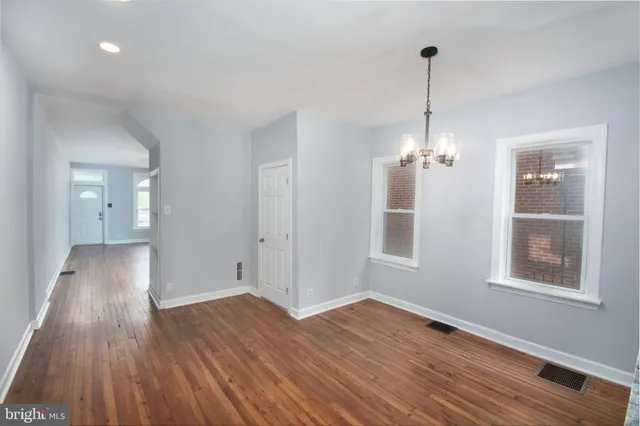 a view of empty room with wooden floor and windows