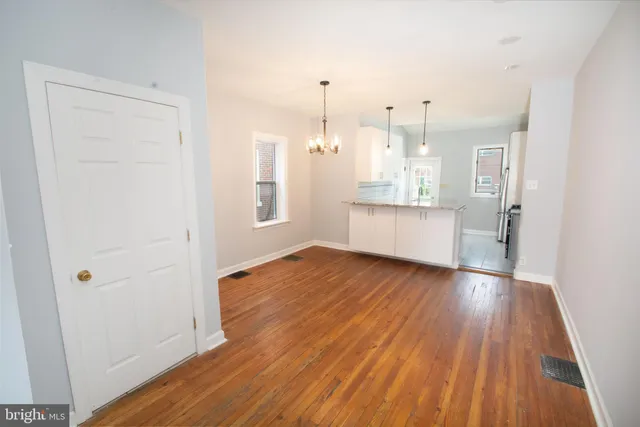 a view of a kitchen with wooden floor and a window