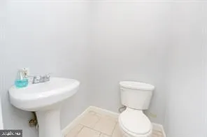 a white toilet sitting next to a white sink
