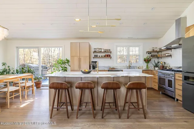 a kitchen with stainless steel appliances granite countertop table chairs and wooden floor