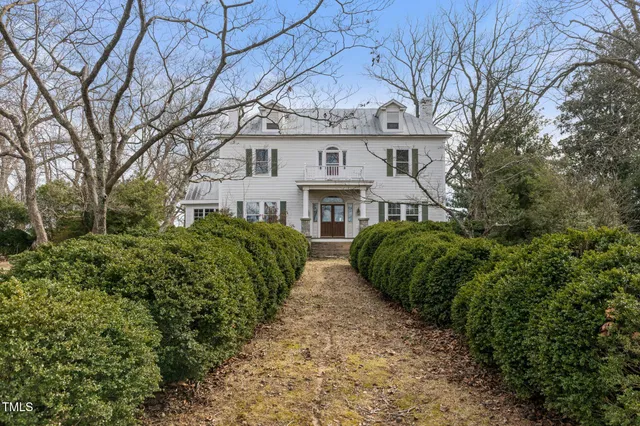 a view of a house with a big yard and large tree