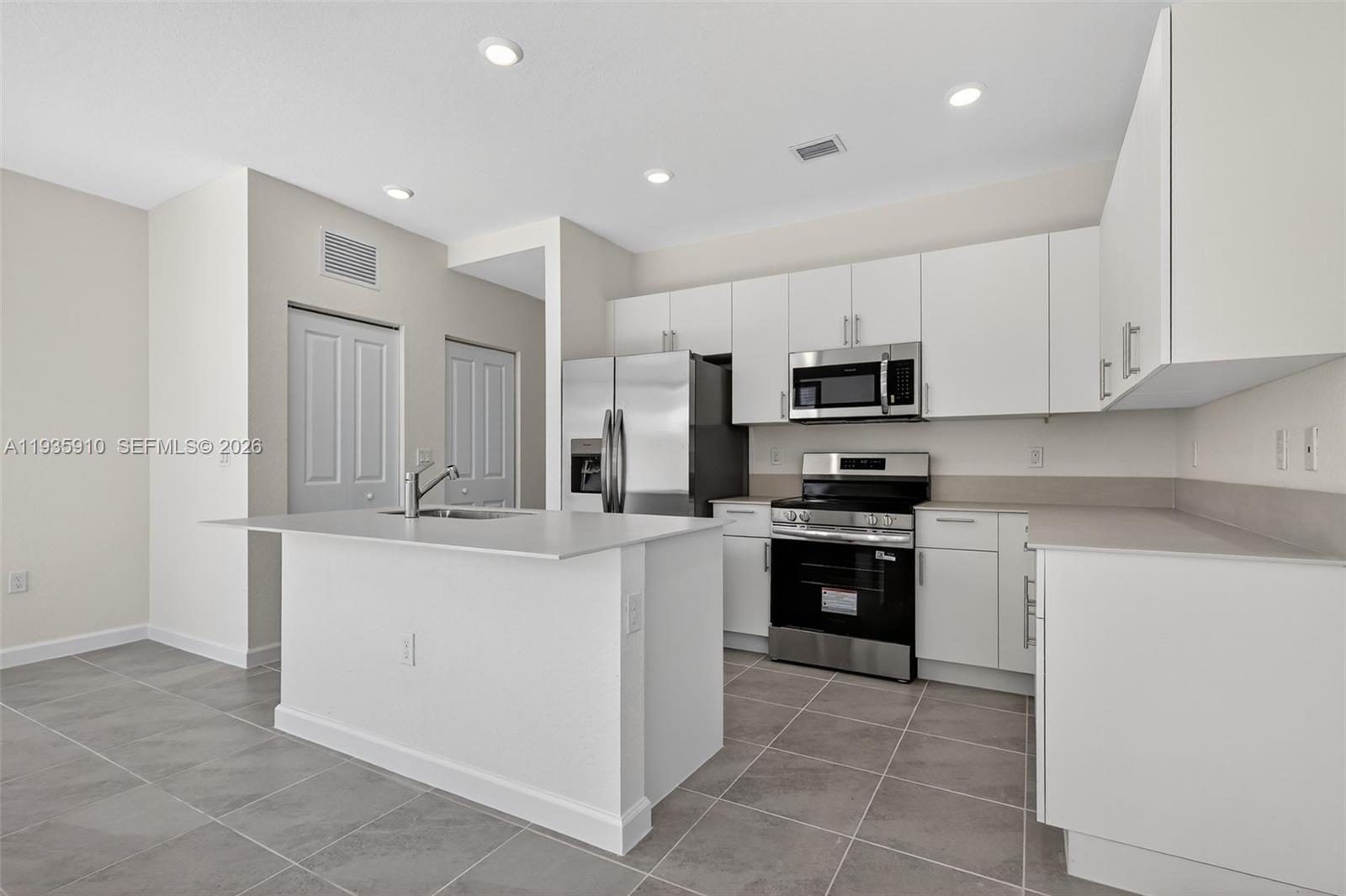 13872 Southwest 262nd Street, Unit 13862 Homestead, FL 33032 - Photo 13 of 43 a kitchen with stainless steel appliances granite countertop a refrigerator and a stove top oven