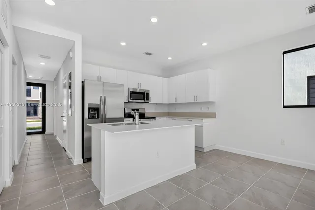 a kitchen with stainless steel appliances a sink stove and cabinets