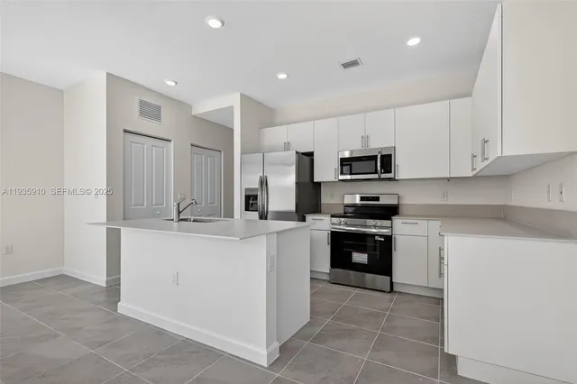 a kitchen with stainless steel appliances granite countertop a refrigerator and a stove top oven
