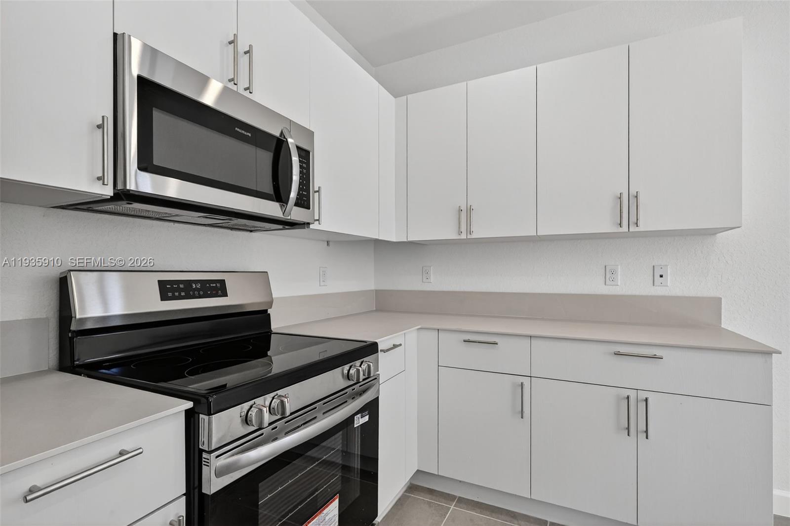 13872 Southwest 262nd Street, Unit 13862 Homestead, FL 33032 - Photo 14 of 43 a kitchen with wooden cabinets and stainless steel appliances