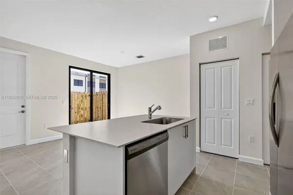 a kitchen with stainless steel appliances granite countertop a sink and a refrigerator