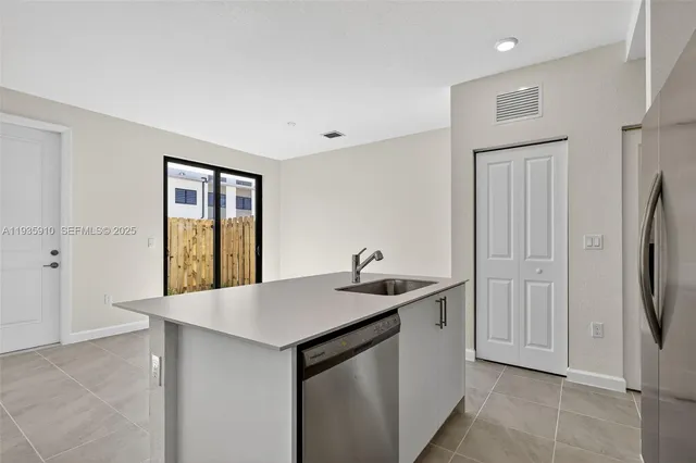 a kitchen with stainless steel appliances granite countertop a sink and a refrigerator