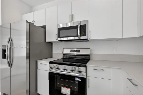 a kitchen with stainless steel appliances a stove microwave and refrigerator