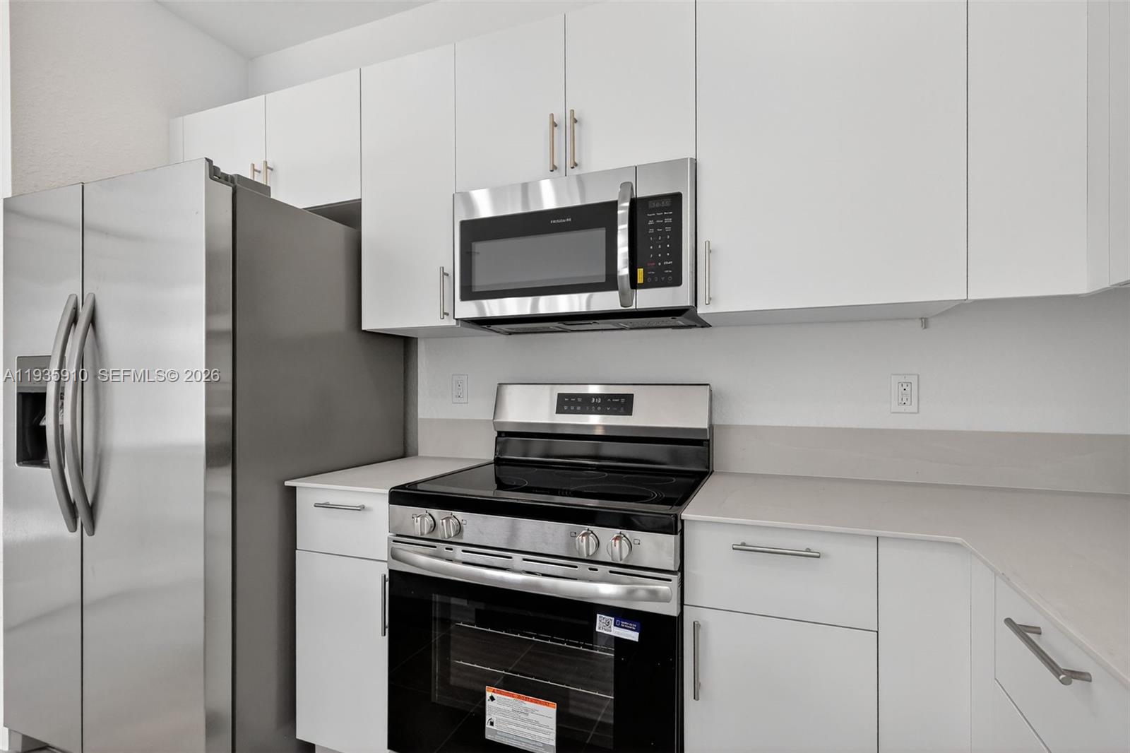 13872 Southwest 262nd Street, Unit 13862 Homestead, FL 33032 - Photo 16 of 43 a kitchen with stainless steel appliances a stove microwave and refrigerator
