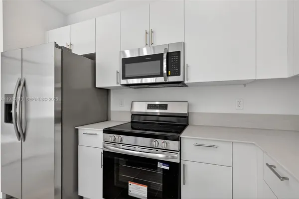 a kitchen with stainless steel appliances a stove microwave and refrigerator
