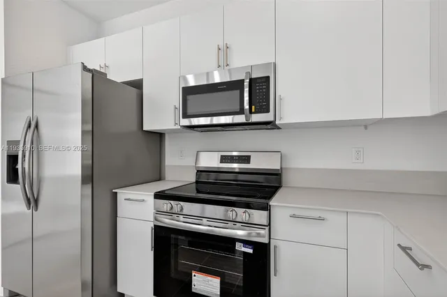 a kitchen with stainless steel appliances a stove microwave and refrigerator