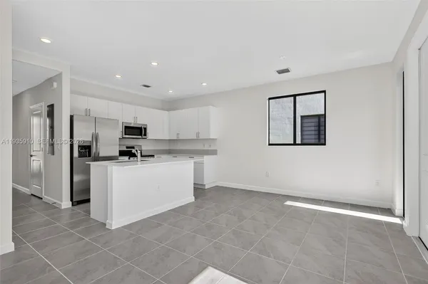 a kitchen with stainless steel appliances a refrigerator sink and cabinets