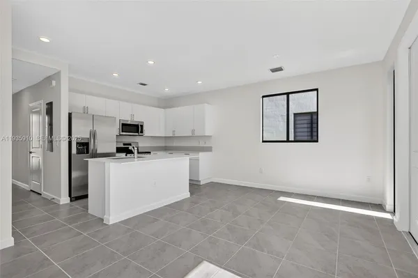 a kitchen with stainless steel appliances a refrigerator sink and cabinets