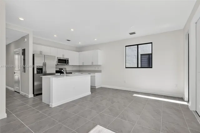 a kitchen with stainless steel appliances a refrigerator sink and cabinets