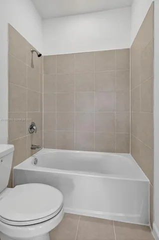 a bathroom with a toilet and a bath tub