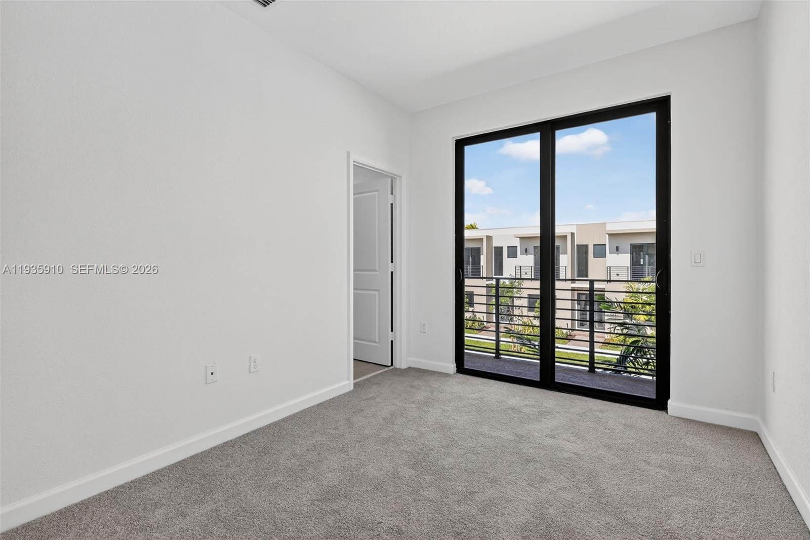 13872 Southwest 262nd Street, Unit 13862 Homestead, FL 33032 - Photo 29 of 43 an empty room with sliding glass door