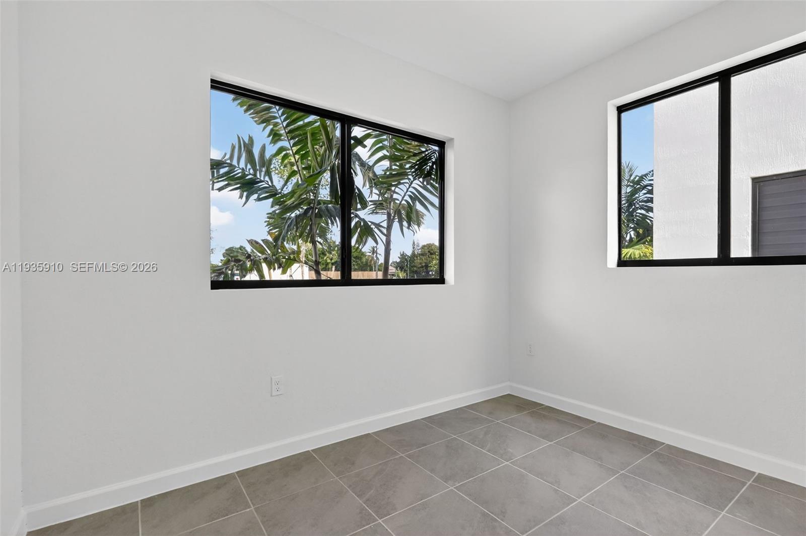 13872 Southwest 262nd Street, Unit 13862 Homestead, FL 33032 - Photo 6 of 43 an empty room with windows and painting on the wall