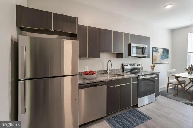 a kitchen with stainless steel appliances a refrigerator stove microwave and sink