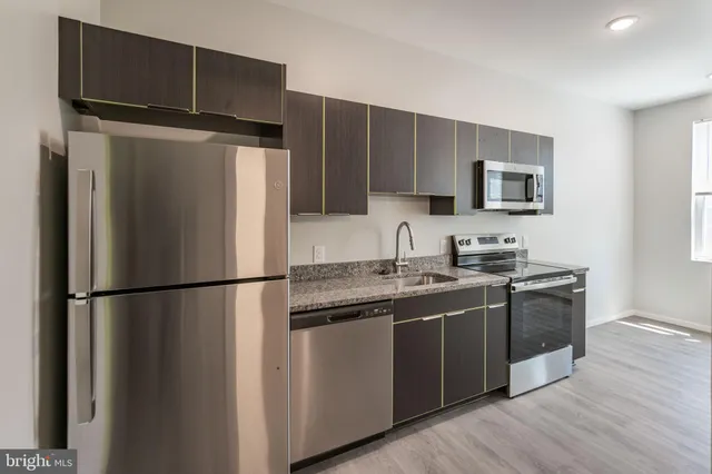 a kitchen with stainless steel appliances a refrigerator stove and microwave