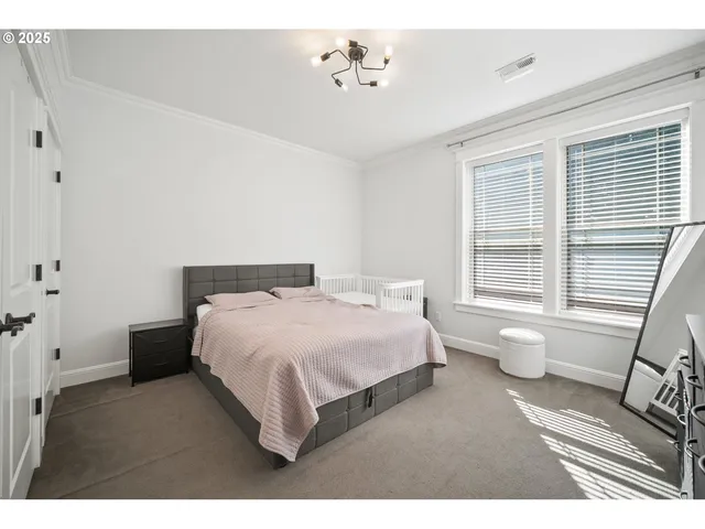 a spacious bedroom with a bed and wooden floor