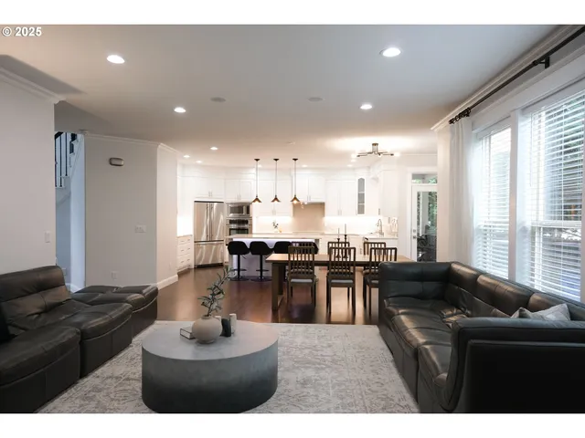 a living room with furniture kitchen and a large window