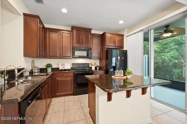a kitchen with kitchen island granite countertop a sink stove and refrigerator
