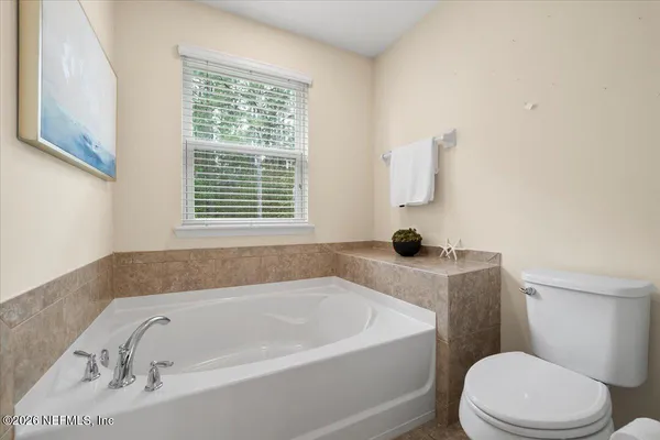 a white bath tub sitting next to a toilet