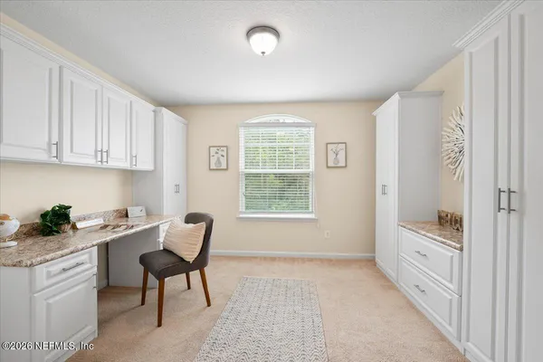 a kitchen with white cabinets and wooden floor