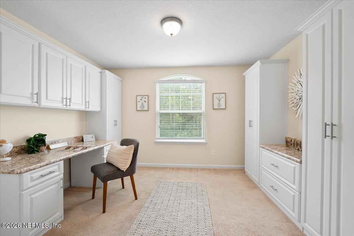 197 Paradas Place St. Augustine, FL 32092 - Photo 28 of 46 a kitchen with white cabinets and wooden floor