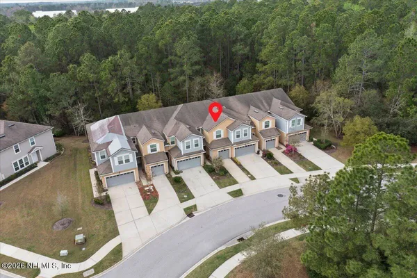 an aerial view of residential house with outdoor space and trees around