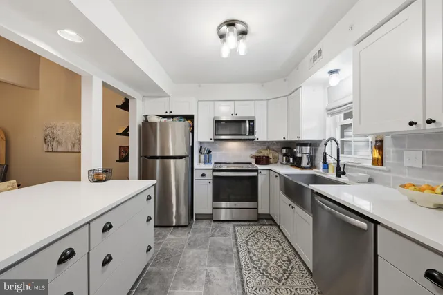 a kitchen with stainless steel appliances a refrigerator sink and microwave