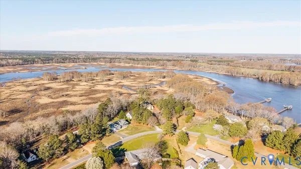 an aerial view of ocean and residential houses with outdoor space