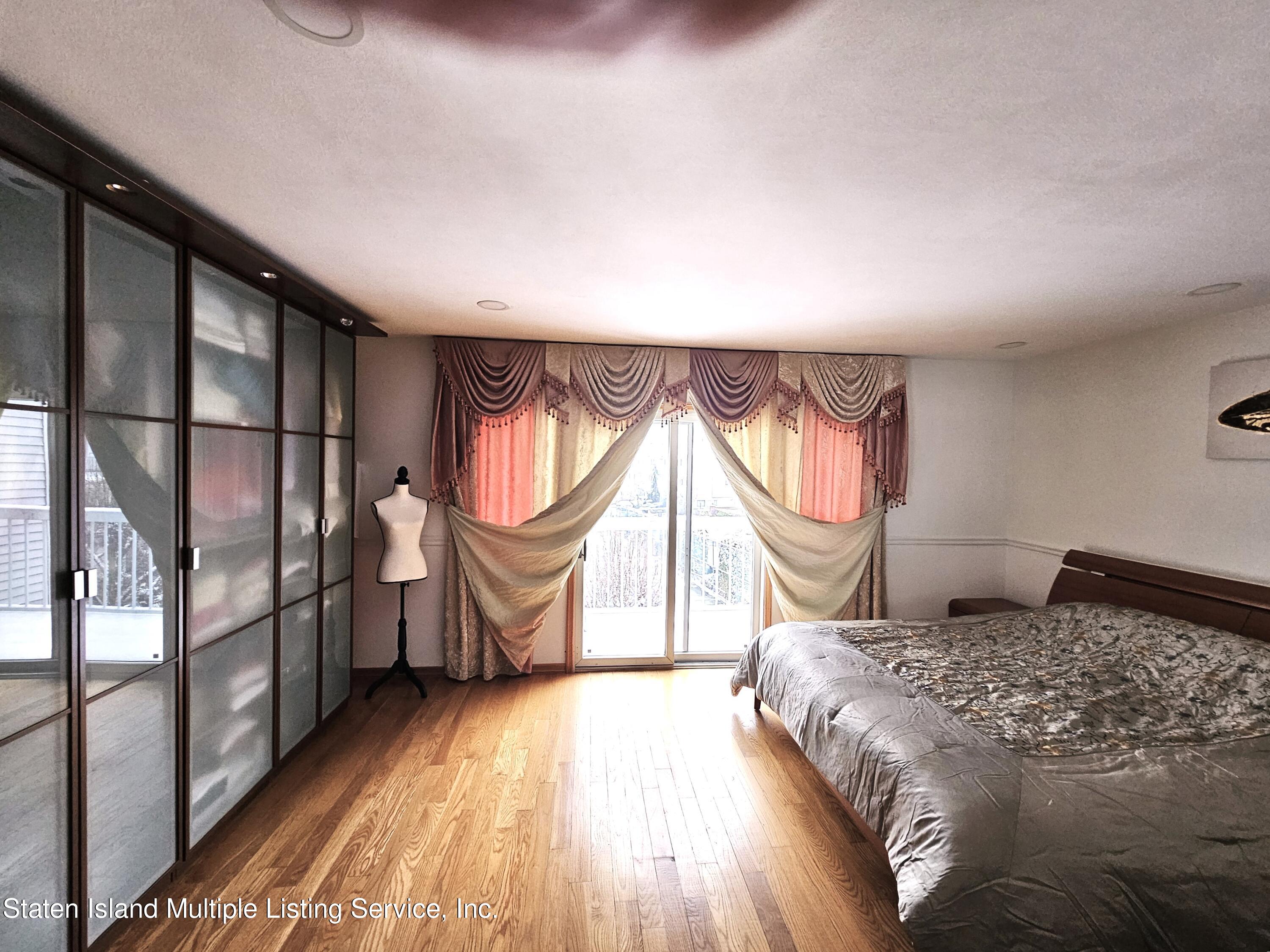 142 Commodore Drive Staten Island, NY 10309 - Photo 15 of 26 a bedroom with a bed and a large window with outer view