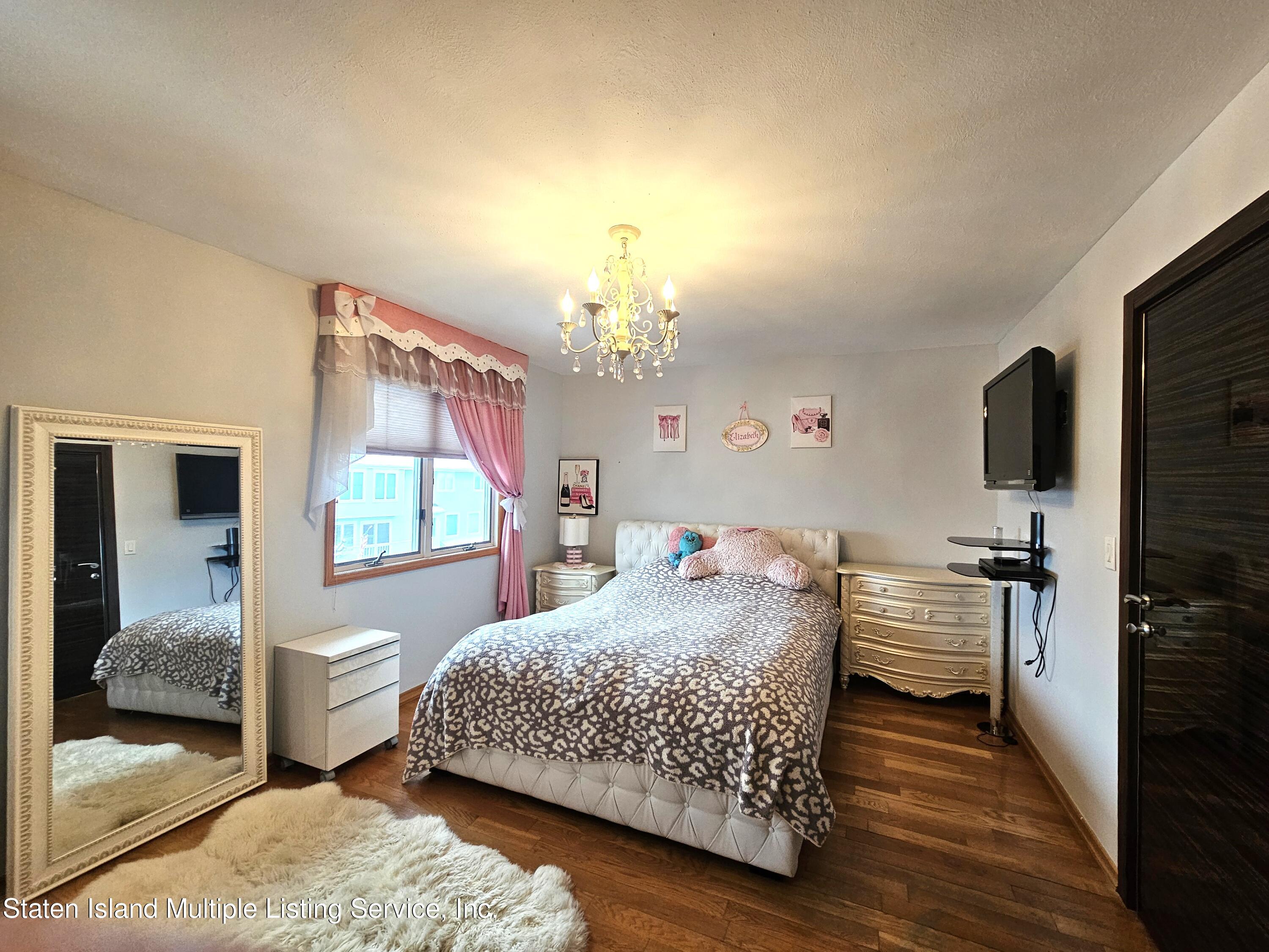 142 Commodore Drive Staten Island, NY 10309 - Photo 21 of 26 a bedroom with a bed and wooden floor