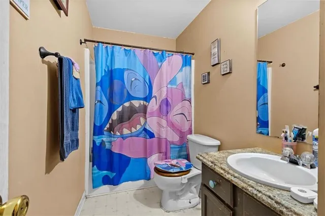 a bathroom with a sink mirror vanity and toilet