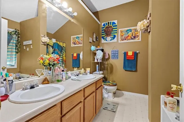 a bathroom with a sink mirror vanity and toilet