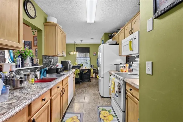 a kitchen with stainless steel appliances granite countertop a lot of cabinets a stove and a sink