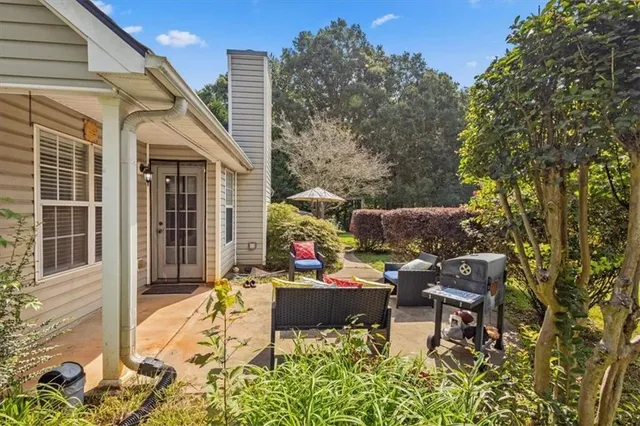 a view of a patio with table and chairs and potted plants