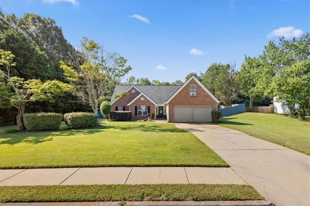 a front view of a house with yard and green space