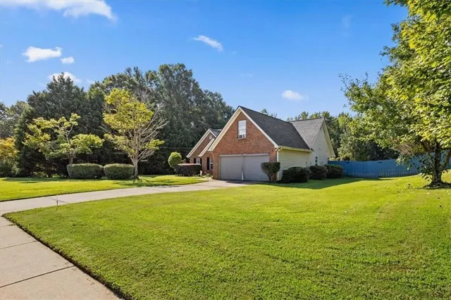 a front view of a house with a yard and trees