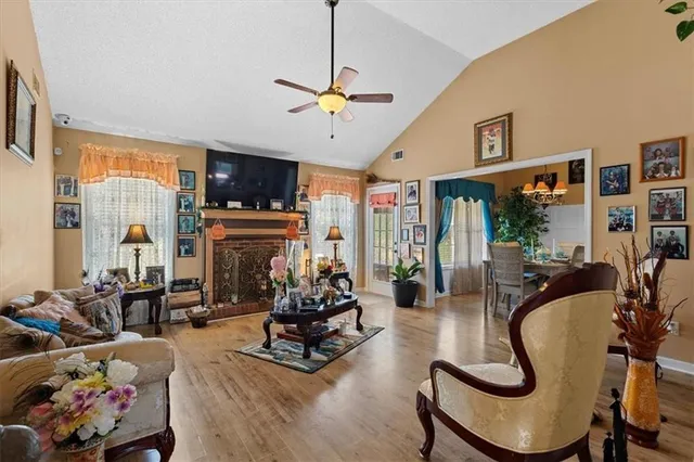 a living room with furniture a flat screen tv and floor to ceiling window