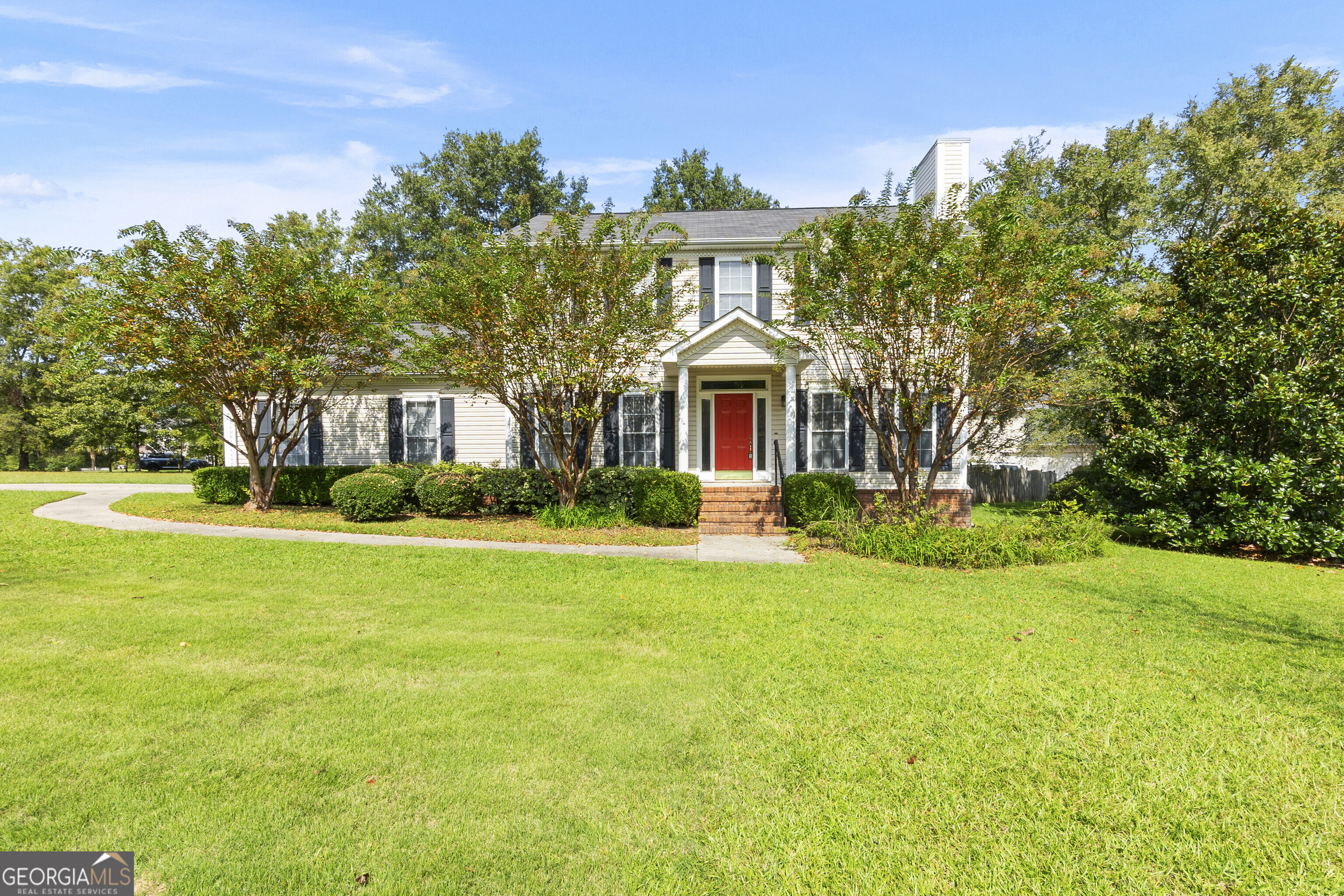 a front view of a house with yard and green space