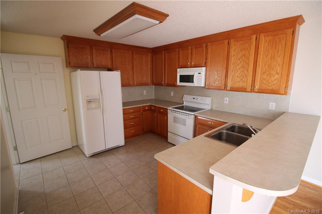1215 Micol Road Newton, NC 28658 - Photo 4 of 12 a kitchen with stainless steel appliances granite countertop a refrigerator sink and cabinets