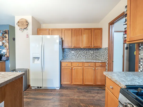 a kitchen with stainless steel appliances granite countertop a refrigerator and a stove